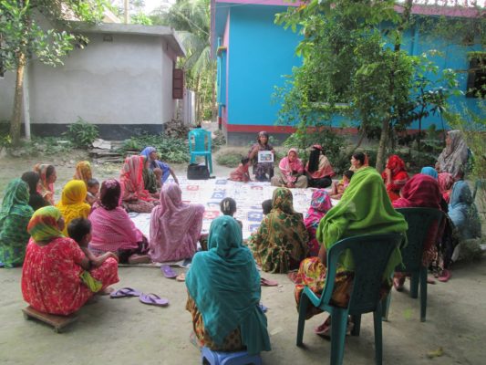 women sitting on the ground in a circle, discussing