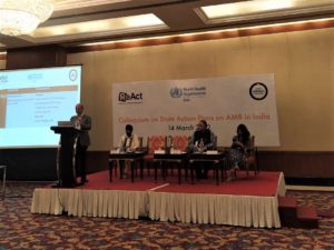 Rajib dasgupta speaking at a podium in front of a panel