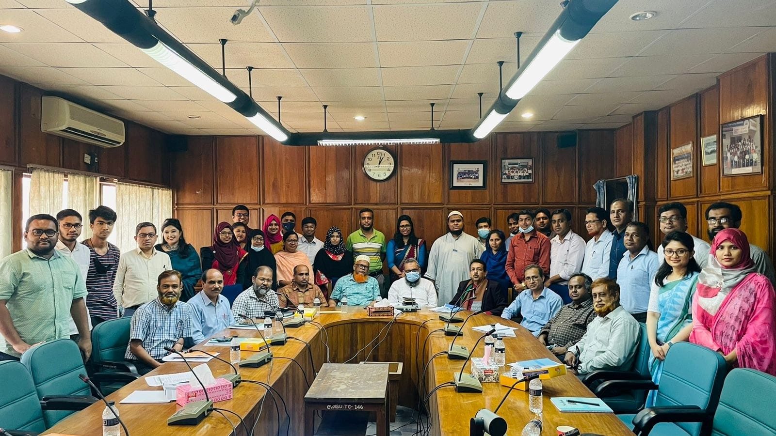 large group shot of people in wood-panelled room