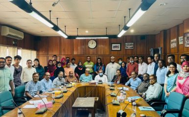 large group shot of people in wood-panelled room