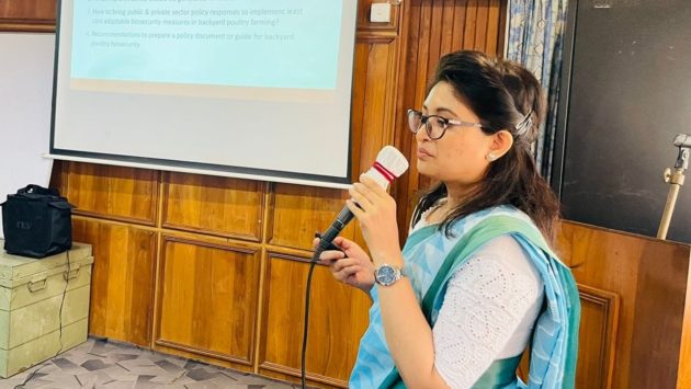 woman speaking into a mic in front of a powerpoint presentation