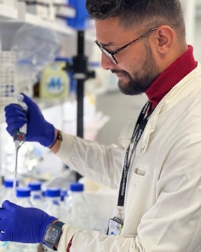 man in lab coat using a pipette in a laboratory