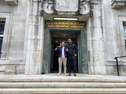 two men standing on steps of LSHTM